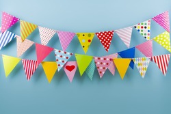 Birthday fest garlands from colorful triangular flags on blue background