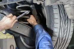 Hands mechanics to repair the suspension on the car