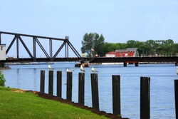 Seagulls sit on wooden pilings in front of St. Josephs' railroad swing bridge in St. Joseph, Michigan.