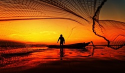 Fisherman throwing his net at the nature lake