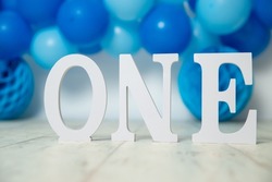sliver, blue and white decoration for a 1st birthday cake smash studio photo shoot with balloons, paper decor, cake and topper. High quality photo