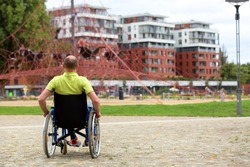 man on wheelchair looking at high net climber, rope playground