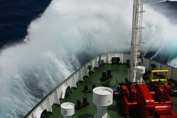 Big wave rolling over the snout of the ship