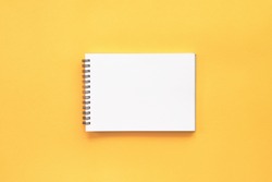 Blank notebook on yellow background.