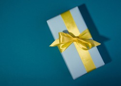 Gift boxes with different colors on a banner template. Blue gift box and yellow bow against bold blue background.