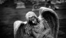 Gravestone grave stone headstone in cemetery angel statue grief and remembrance wings and prayer