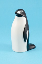toy penguin figurine on blue background. cute plastic home decoration.