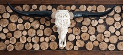 Decorative carved skull of longhorn bull on the wall with wooden background