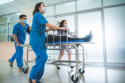 Emergency Department: Doctors, Nurses and Paramedics Run and Push Gurney  Stretcher with Seriously Injured Patient towards the Operating Room. Modern Hospital with Professional Staff.