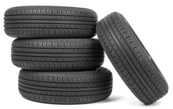 Stack of four wheel new black tyres, isolated on white background