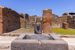 Ruins of an ancient city destroyed by the eruption of the volcano Vesuvius in 79 AD near Naples, Pompeii, Italy. A fountain for public use on one of the streets