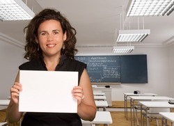 Woman holding a black sign with a maths classroom on the background