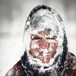 Man covered by snow in heavy snowstorm.
