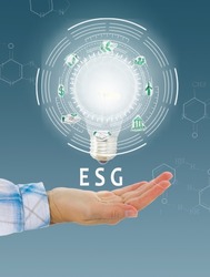 hand holding glowing bulb with esg circle concept of environmental, social and governance