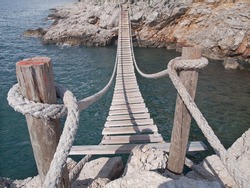 hanging wooden bridge connect rocky sea cost