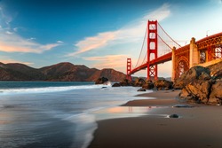 Famous Golden Gate Bridge view from the hidden and secluded rocky Marshall's Beach at sunset in San Francisco, California
