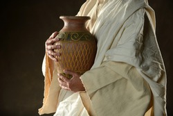 Jesus Holding a jug of water on a dark background