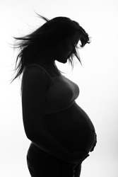 Silhouette of a pregnant woman, a studio portrait.