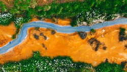 Top down aerial view from drone on geothermal icelandic are in Iceland Seltun near Krysuvik and Kleifarvant lake, blue water and orange colorful ground texture structure hot spring and mud background