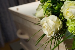 A coffin with a flower arrangement in a morgue