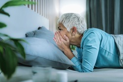 Circadian rhythm sleep disorder. Worried mature woman in bed staying awake late at night