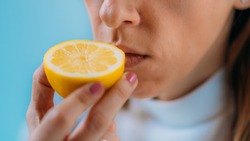 Anosmia or smell blindness, loss of the ability to smell, one of the possible symptoms of covid-19, infectious disease caused by corona virus. Woman Trying to Sense Smell of a Lemon