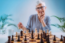 Senior woman playing chess. Cognitive rehabilitation activity.