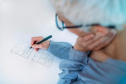 Cognitive training. Senior woman solving sudoku puzzles.