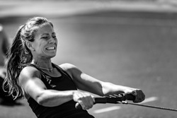 Female athlete on rowing machine on cross competition.