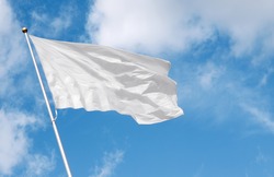 White flag waving in the wind against cloudy sky. Perfect mockup to add any logo, symbol or sign