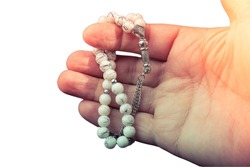 Hand with prayer beads isolated on white background.