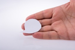 Hand holding a blank empty speech bubble made white paper