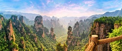 Zhangjiajie Forest Park. Panoramic view above the cliffs and mountains to the colorful valley at sunrise. Picturesque landscape. Majestic nature.