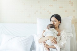 Close up portrait of beautiful young asian Indian or caucasian mother day with newborn baby, copy space with bed in the hospital. Healthcare and medical love lifestyle mother's day concept