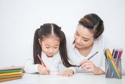 Portrait of mother and daughter learning to write, mother teaching little girl homework how to write, Education study home school mother's day concept 