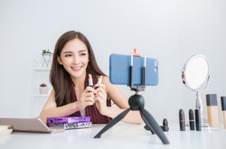 Portrait young asian woman vlog  review giveaway gift product fan following channel recording video make up lipstick cosmetic at home Online influencer girl social media market live steaming concept