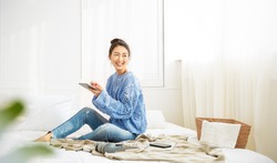 Asian woman with smile use tablet smartphone in blue winter sweater work home, Portrait beauty asia girl hygge relax in bedroom. Technology people connection digital online social media market banner