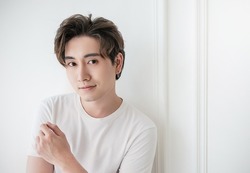 Attractive young handsome smiling face positive asian, korean happy casual man, stay home minimal lifestyle. Closeup portrait of asia middle age 20s man wearing white shirt in studio. Young model boy 