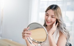 Closeup portrait of young beautiful asian girl with mirror makeup routine with copy space. Beauty influencer woman with perfect glow skin dress up. Healthcare woman lifestyle cosmetic blogger concept