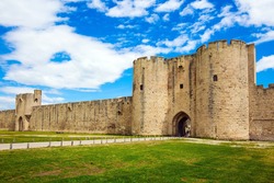 Southern France. Journey to History. Picturesque powerful gates and fortifications defend the port city of Aigues-Mortes. Around the walls are green lawns