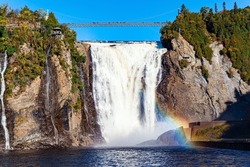 Picturesque rainbow glitters in water splashes. The powerful waterfall of Montmorency. Travel to Canada. Surroundings of the ancient picturesque city of Quebec. 