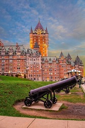 Cast iron antique cannons on the Quebec waterfront. Hotel Chateau Frontenac, the most photographed hotel in the world. Ancient architecture of Quebec Historic Center. Sunset