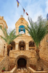 Small courtyard in Monastery of St. Gerasim of Jordan. The male monastery of the Jerusalem Orthodox Church in the Judean Desert. The bell tower topped with a gilded Orthodox cross. 