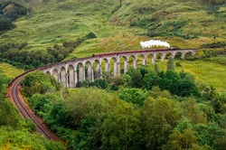 Steam train on a famous Glenfinnan viaduct, Scotland, Great Britain