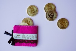 Golden btcoins outof a pink wallet
