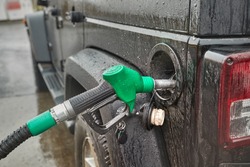 Refueling an off-road car, holding the nozzle at the petrol station