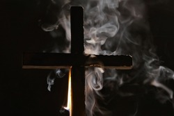 Burning cross with smoke in dark night