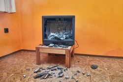 Olt tube TV set smashed with an axe, glass CRT imploding, pieces in the room everywhere