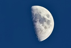 The Moon detailed shot in blue daylight sky, taken at 1600mm focal length, first quarter phase, dusk light