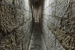 Narrow passage between castle walls made of stone blocks